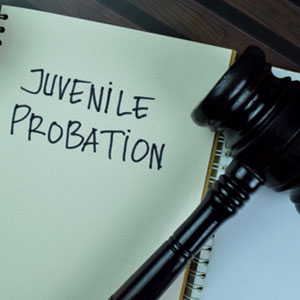 A notebook with "Juvenile Probation" written on it, next to a judge's gavel - The Law Office Of Michael D. Barber